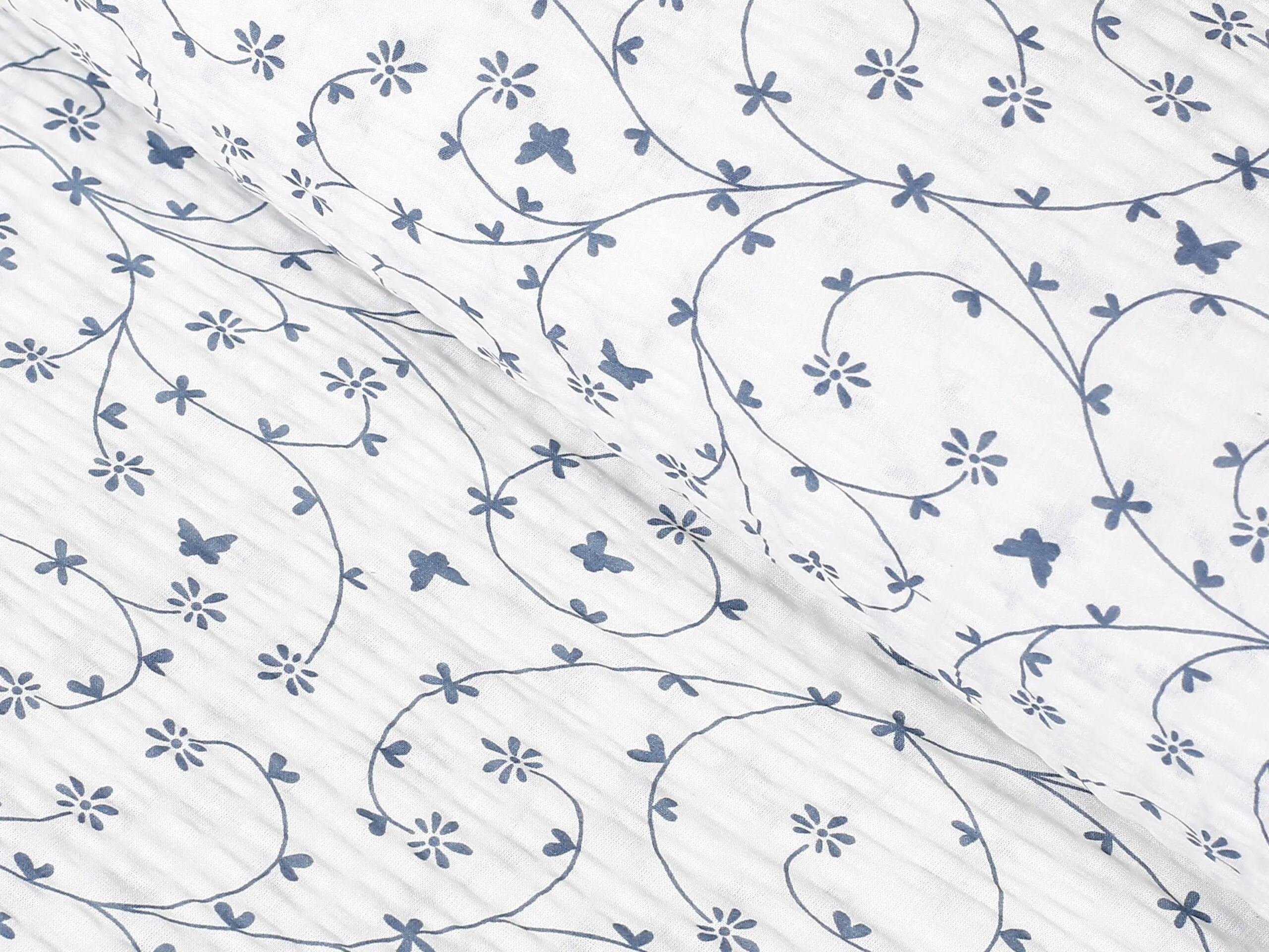 Krepová látka modří motýlci na bílé metráž značky Škodák.