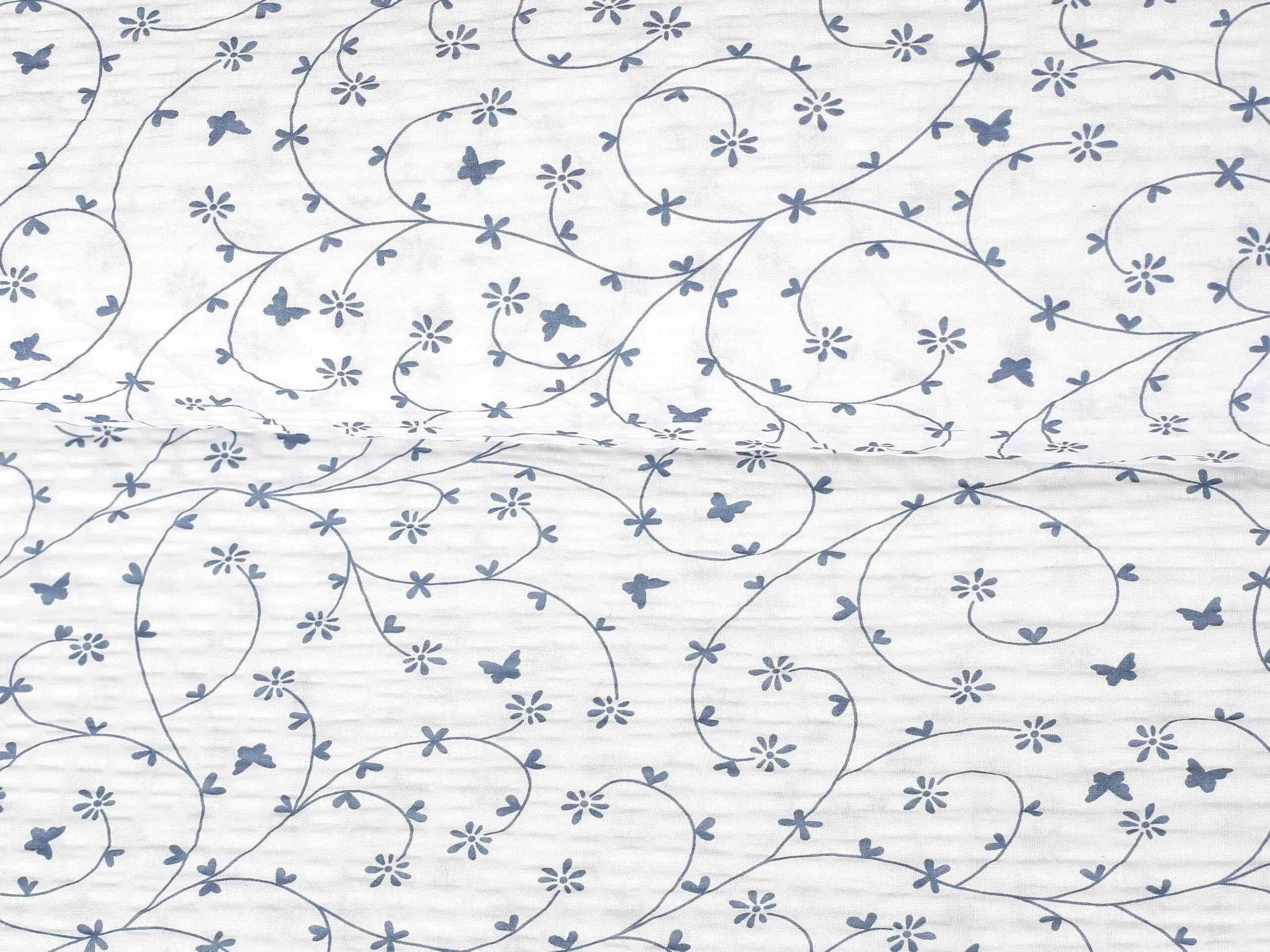Krepová látka modří motýlci na bílé metráž značky Škodák.