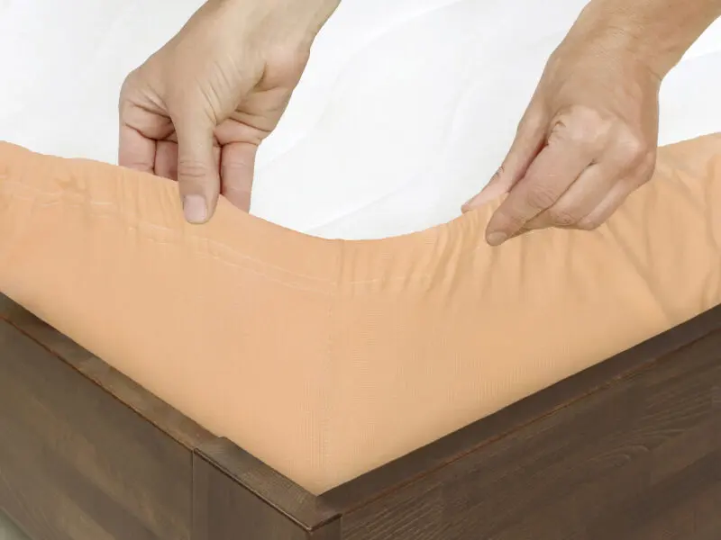Jersey prostěradlo lososové pro hotely s napínací gumou značky Škodák.
