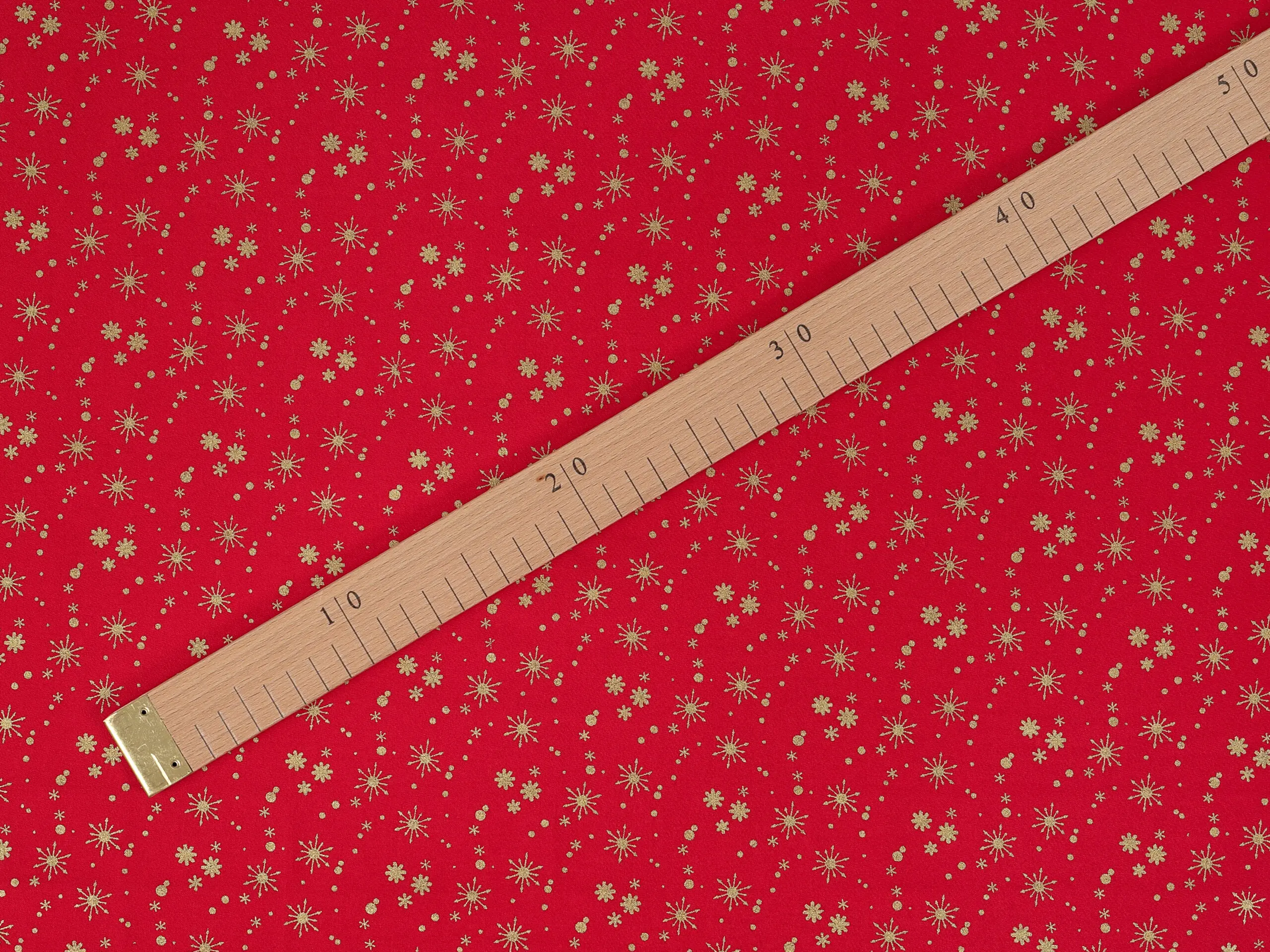 Bavlněná látka zlaté vločky na červené metráž šířka 142 cm značky Škodák.