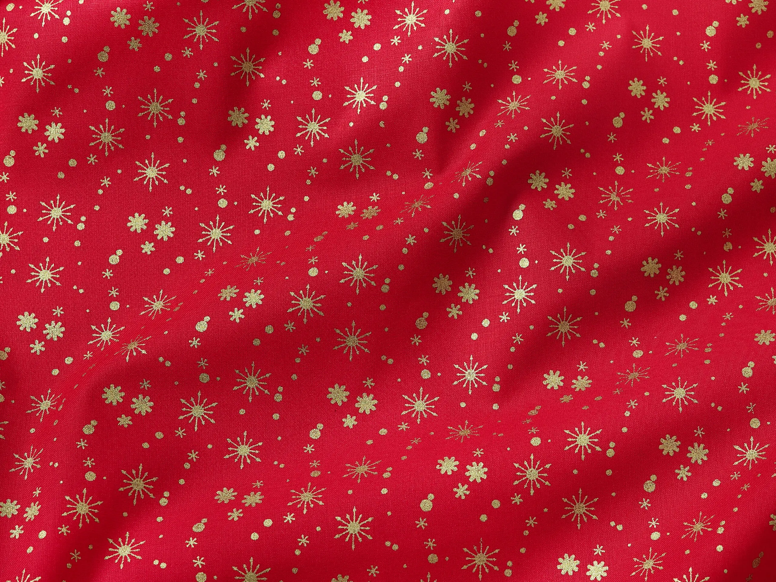 Bavlněná látka zlaté vločky na červené metráž šířka 142 cm značky Škodák.