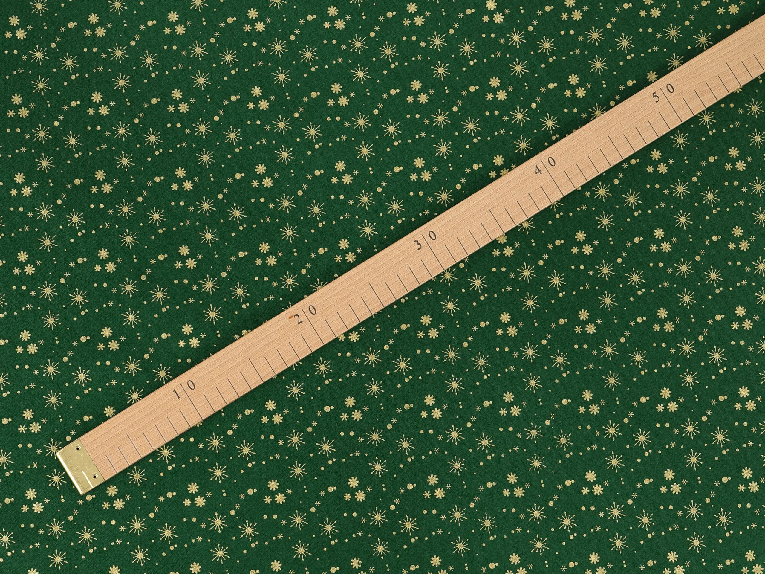 Bavlněná látka zlaté vločky na zelené metráž šířka 142 cm značky Škodák.