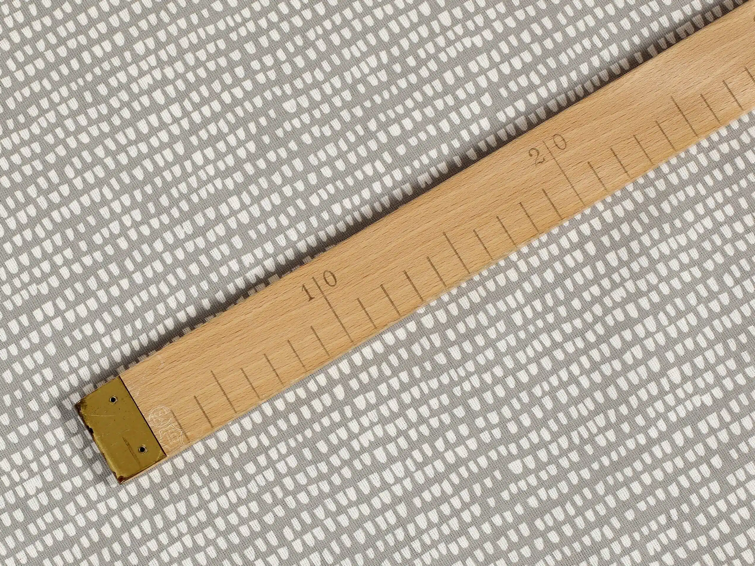 Bavlněná látka zrníčka na šedé metráž značky Škodák.